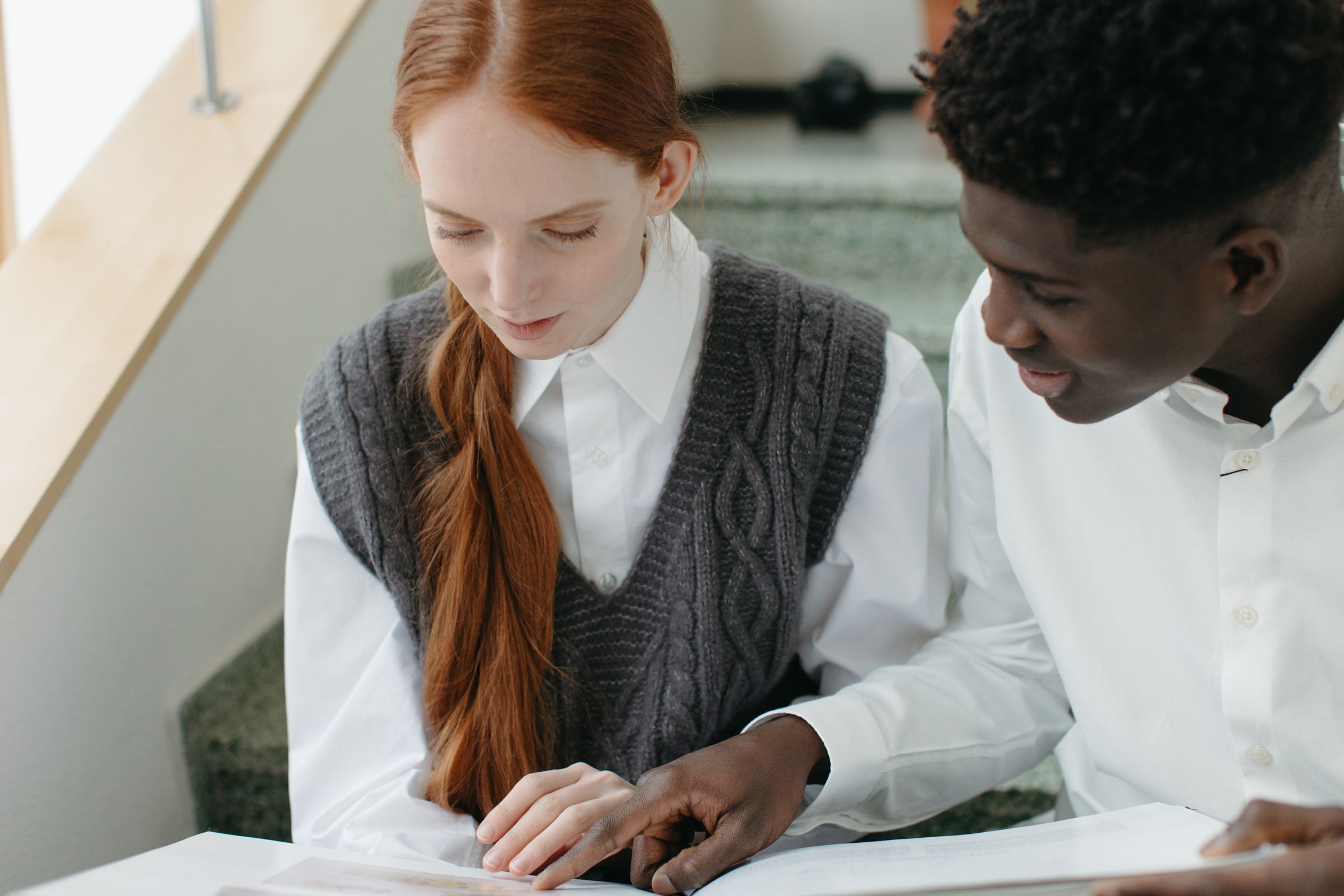 Two students reading a page together at a desk